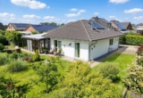 Vorder-Seitenansicht-Garten - Modern-Innovativ–Stilvoll. Gepflegter Bungalow mit großem Wintergarten. Ein Zuhause zum Wohlfühlen.